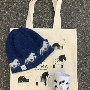 Þetta fallega Kidka gjafasett inniheldur hestabolla, hlýja bláa hestahúfu úr íslenskri ull, framleidda á Íslandi, og hestatösku sem fylgir frítt með