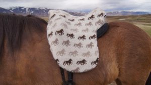 "Fákur" saddlecover beige. Beige saddlecover with lightbrown and brown horses. Made from Icelandic wool